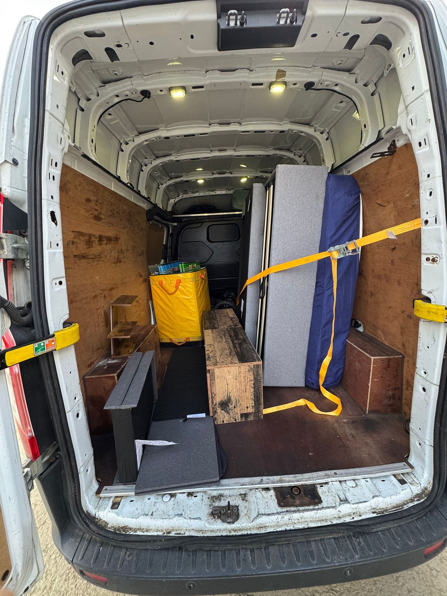Interior of the van with scooter, mattress and secured load
