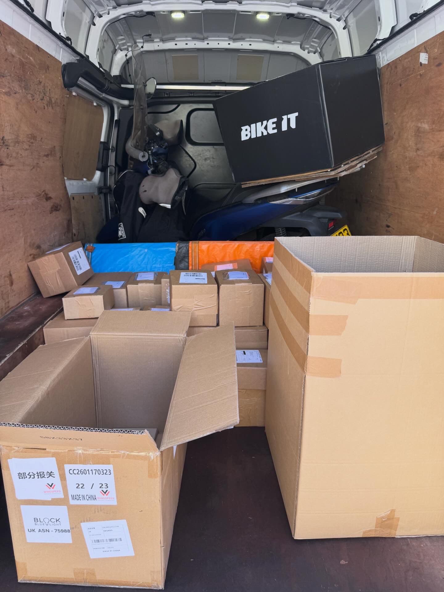 Van loaded with commercial cargo boxes alongside a BIKE IT motorcycle box